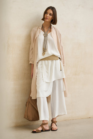 look elegante mujer en capas con vestido blanco fluido y chaqueta beige